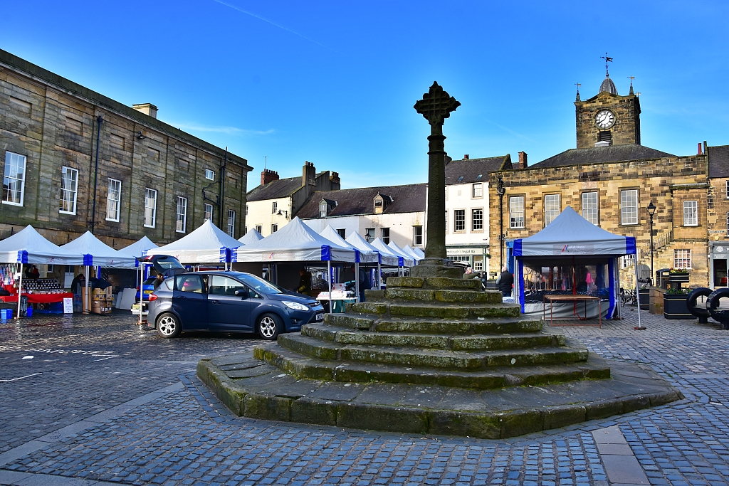 The Market Cross in Alnwick as the Saturday Market is Being Set Up © essentially-england.com
